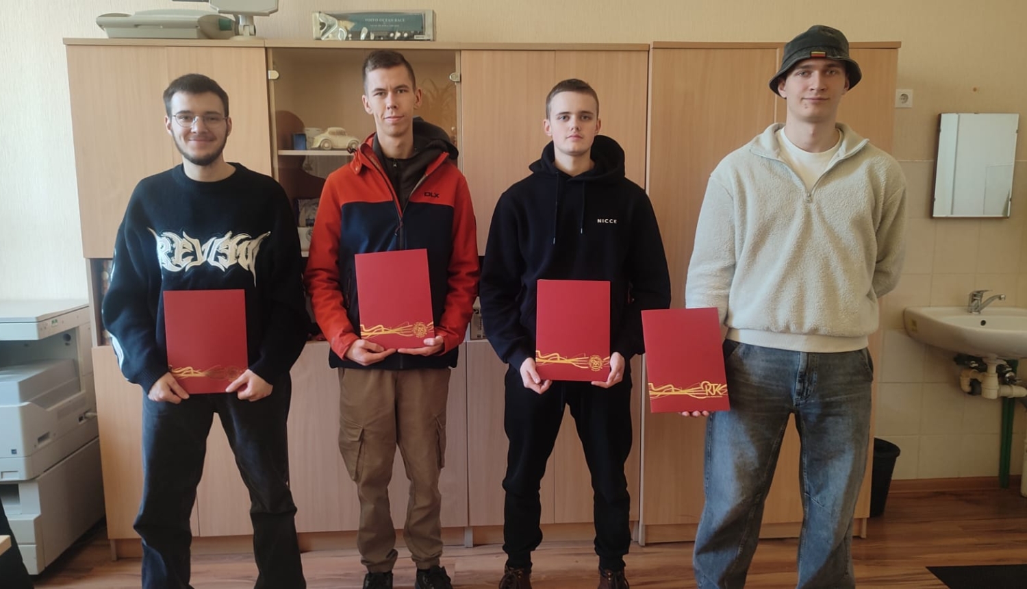 Puiši stāv ar diplomiem
